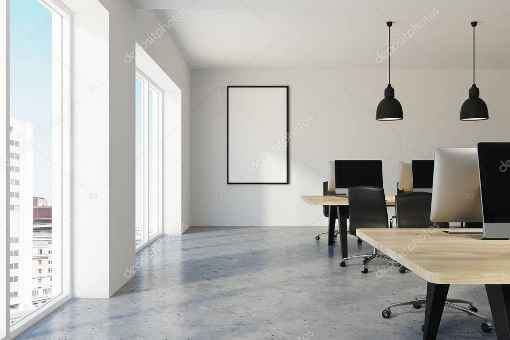 White contemporary office interior with a concrete floor and rows of computers with blank screens standing on wooden desks. A frame mock up poster on the wall. 3d rendering