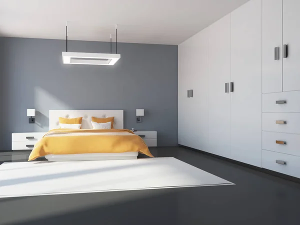 Gray and white bedroom interior with a concrete floor, a king size bed and a white wardrobe. 3d rendering mock up