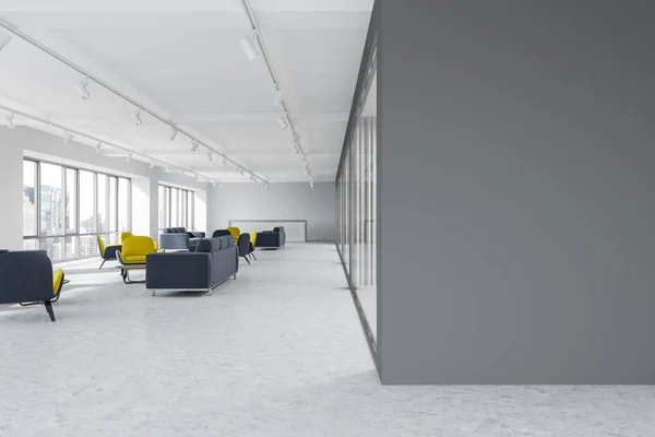 Corridor of a luxury office with dark gray walls, a concrete floor and yellow and gray armchairs standing next to gray sofas. 3d rendering mock up