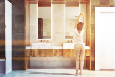 Çift banyo lavabo ile iki dar uzun boylu çerçeveli ayna üstünde bir ahşap duvar ile klasik tuvaletinde asılı. Bir kadın. 3D render tonlu görüntü