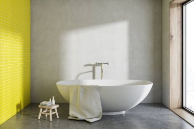 Bu minimalist gri ve sarı banyo bir beton zemin üzerinde duran asılı bir havlu ile beyaz küvet. Küçük bir sandalye. 3D render alay