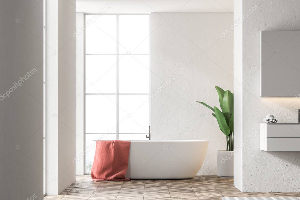 White bathtub with a red towel hanging on it standing in a modern bathroom interior with white walls. A sink to the right. 3d rendering mock up