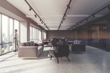 Ofis bekleme odası iç çatı pencereleri, bir beton zemin ve kahverengi ve gri koltuklar yanındaki gri kanepeler ayakta. Bir işadamı 3d render resim tonda