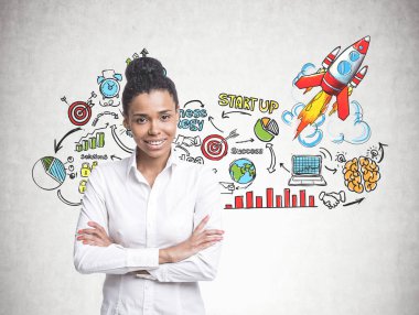 Bir beyaz gömlek ve siyah giyen gülümseyen kendine güvenen genç Afro-Amerikan kadın çapraz kolları ile ayakta ve görüntüleyiciyi seyir pantolon. Taslak proje başlatmak kavram a başlatılması ile beton duvar