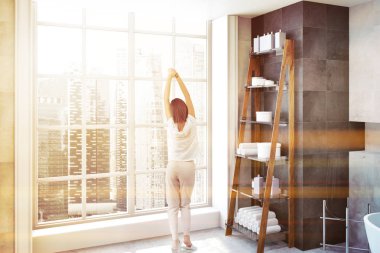 Banyo dolaba havlu ve lüks banyo iç bir cityscape ile büyük bir pencere yakınında duran şişe ile. Bir kadın. 3D render tonlu görüntü