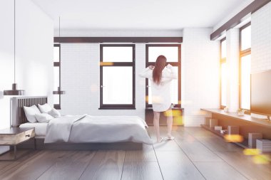 Kadın bir yatak odası iç beyaz ve beyaz tuğla duvarlar, ahşap bir zemin, bir çift kişilik yatak ve bir Tv önünde ayakta ayarlayın. 3D render sahte kadar çift tonlu görüntü pozlaması