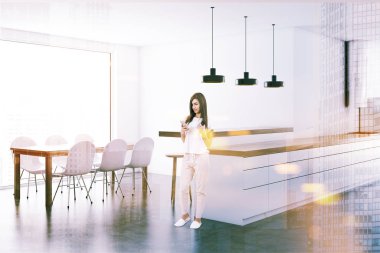 Modern beyaz mutfak iç uzun bir yemek masası ve beyaz sandalye ile bir stüdyo dairede bir smartphone ayakta olan kadın. 3D render resim çift pozlama tonda