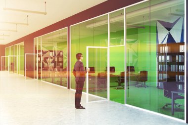 Parlak yeşil ofis iç geometrik duvar desen ve bilgisayar tabloları satırları duran genç iş adamı. Bir cam duvar ve kapı. Bir lobi. Yan görünümü. 3D render sahte tonlu görüntü
