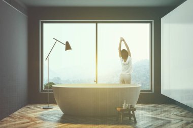 Bir dağ manzaralı bir beyaz ve gri duvar panoramik banyo iç germe kadın. Zarif bir beyaz küvet pencerenin duruyor. 3D render sahte kadar çift tonlu görüntü pozlaması