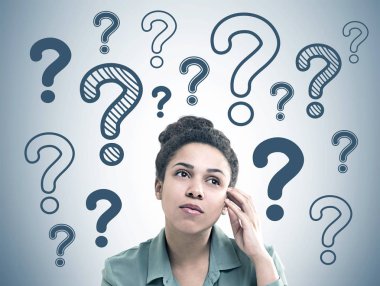 Baş ve omuzlar yeşil tişört giyen bir düşünceli genç Afro-Amerikan kadın portresi. Birçok mavi soru işaretleri gri bir duvar.