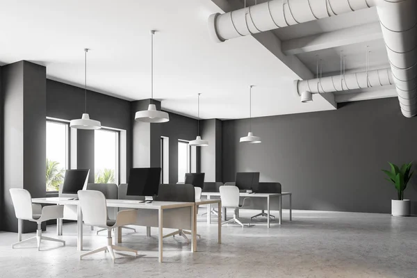 Dark gray industrial style office corner with a white floor, loft windows, simple white tables and chairs. Computers on desks. 3d rendering mock up