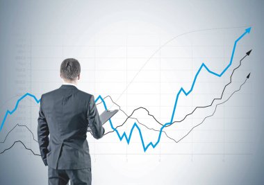 Dikiz gri elbiseli bir klasör tutan genç bir işadamı. O iple çekiyor. Birçok renkli oklar ve büyüyen grafikler bir gri duvar arka plan