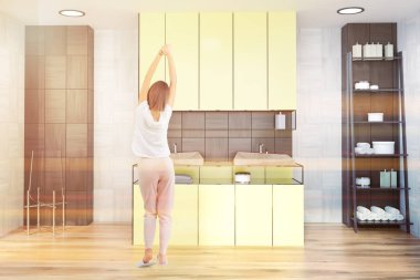 Beyaz ve siyah ahşap duvar banyo havlu ve şampuan yakınında için raflar ile sarı bir çift lavabo. Bir kadın. 3D render sahte tonlu görüntü