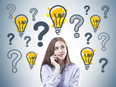 Dreamy young businesswoman wearing a blue shirt is standing near a gray wall with many question marks and light bubls. clipart