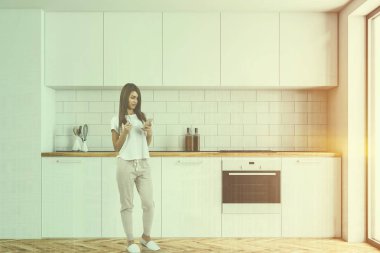 Modern mutfak beyaz duvarlar ve ahşap bir zemin ile ayakta beyaz mutfak tezgahı. Kadın 3d render sahte kadar çift tonlu görüntü pozlaması