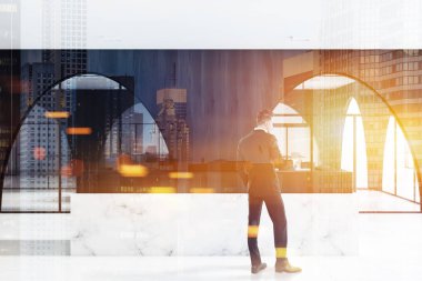 İşadamı bir mermer ve ahşap resepsiyon masası ayakta beyaz zemin, modern ofis lobisinde yakınındaki koyu ahşap duvarlar ve panoramik pencereler kemerli. 3D render sahte kadar çift tonlu görüntü pozlaması