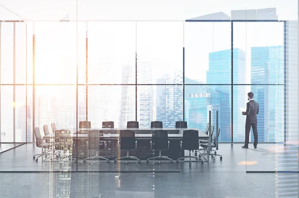 Bir modern panoramik ofis toplantı odası ile gri bir tablo sabah ayakta iş adamı. 3D render sahte kadar çift tonlu görüntü pozlaması