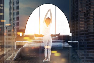 Bir yatak odası iç koyu gri duvarlar, bir ana yatak ve iki lamba başucu tabloları üzerinde duran bir kadın. Kemerli pencereler. 3D render sahte kadar çift tonlu görüntü pozlaması