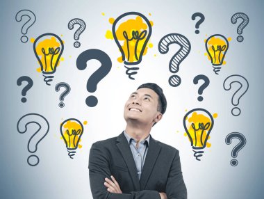Kurucusu takım ayakta pek çok soru işaretleri ve hafif bubls bir gri duvarının yakınında güvenli ve neşeli Asya başlangıç.