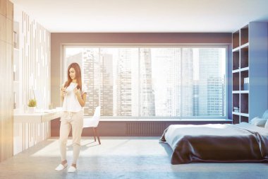 Bir çatı katı yatak odası iç gri ve ahşap duvarlar, gri bir karyola ve yanında duran iki uzun boylu kütüphaneler ile kadın. Bir ev ofisi 3d render alay tonda görüntüsü