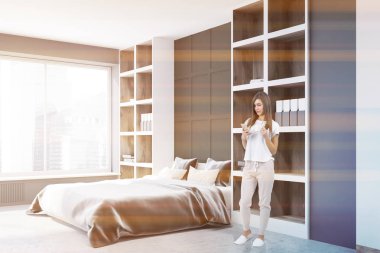 Gri duvarlar, gri bir karyola ve yanında duran iki uzun boylu kütüphaneler ile bir yatak odası iç kadında. 3D render sahte tonlu görüntü