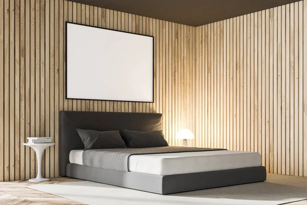 Side view of a master bedroom interior with wooden walls, a gray master bed and a lamp standing on a bedside table. A horizontal poster frame on the wall. 3d rendering mock up