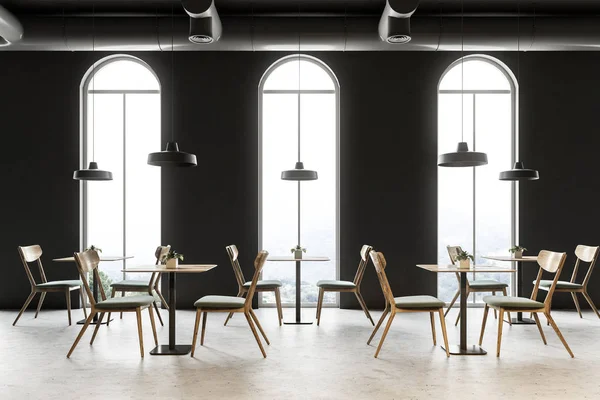 Industrial style restaurant interior with dark gray walls, a concrete floor, arched windows and wooden tables with chairs. 3d rendering mock up