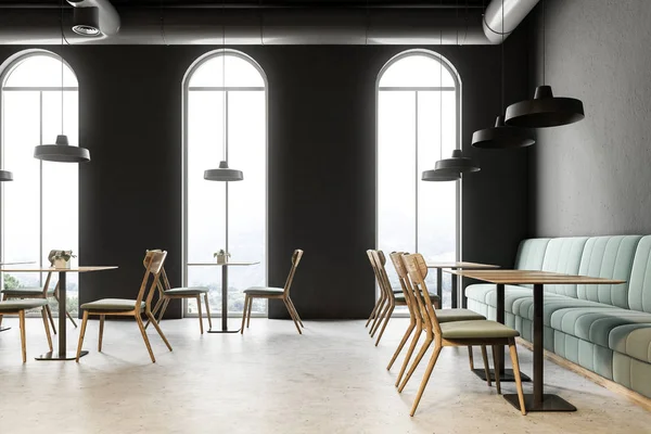 Industrial style cafe restaurant with dark gray walls, a concrete floor, arched windows and wooden tables with chairs. Green sofas. 3d rendering mock up
