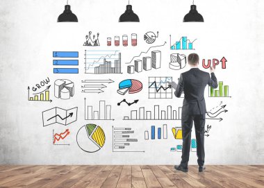 Grafikler ve haritalar mind yaratıcı ve parlak işe başlamak beton duvara çizim genç başarılı bir iş adamı arka görünümü.