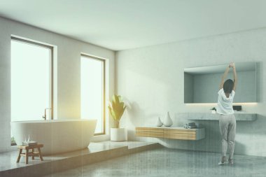 Beyaz duvar banyo iç bir beton zemin, kadında çatı windows, beyaz bir küvet ve lavabo. Köşede bir Bank. 3D render sahte kadar çift tonlu görüntü pozlaması