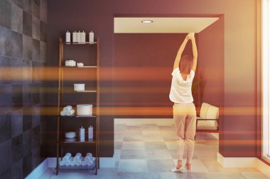 Raf havlu ve geniş banyo iç siyah çini ve gri duvarlar, beyaz bir ahşap zemin ve arka planda beyaz kanepe şampuan ile. Kadın pijama. 3D render tonlu görüntü