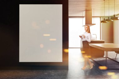 Siyah duvarlar, beton zemin ve uzun ahşap bir masa ile panoramik mutfak iç. Duvardaki büyük boş dikey poster. Bir işkadını 3d render alay tonda görüntüsü