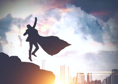 Pelerinli bir kayaya atlama ve modern cityscape arayan bir işadamı silüeti. Tonlu görüntü pozlama sahte katlayın