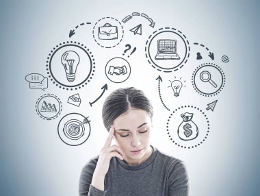 Bir baş ağrısı yanında gri bir duvar üzerinde çizilmiş bir iş planı kroki ile sahip uzun siyah saçlı Genç kadın vurguladı.