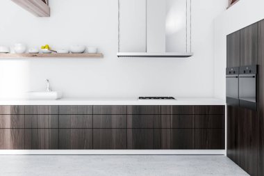 Bir tavan mutfak iç beyaz duvarlar, beton zemin ve koyu ahşap mutfak tezgahı ile yan görünüm. Duvardaki yemekleri ile bir raf. 3D render