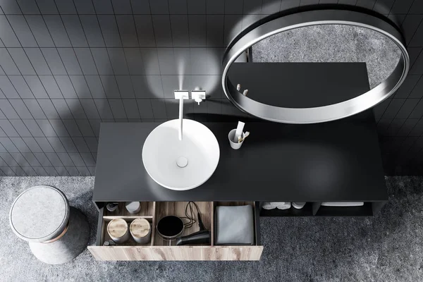 一个圆形白色水槽的顶部视图 在一个黑色瓷砖浴室与混凝土地板的化妆瓶 — 图库照片