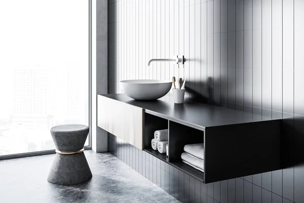 一个圆形的白色水槽的侧面视图与化妆瓶在一个黑色瓷砖浴室与混凝土地板 — 图库照片