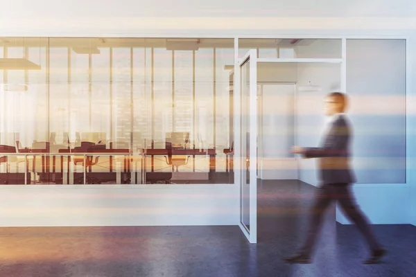 Businessman in a modern law company office lobby with a concrete floor and computer desks standing in a row. An open glass door. 3d rendering mock up toned image blurred