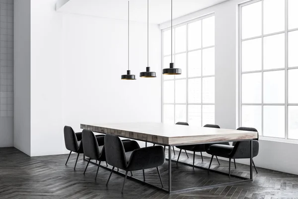 Industrial style dining room corner with white walls, a concrete floor and a long table with black chairs standing around it. 3d rendering mock up toned image
