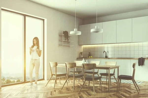 Side view of a French window kitchen with white walls, a wooden floor, a table with chairs and white countertops. A woman 3d rendering toned image double exposure