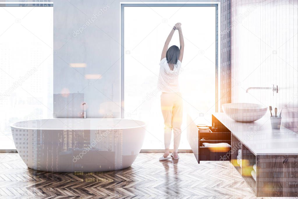 Woman in a loft bathroom interior with white walls, a wooden floor, a white bathtub and a round sink. 3d rendering mock up toned image double exposure