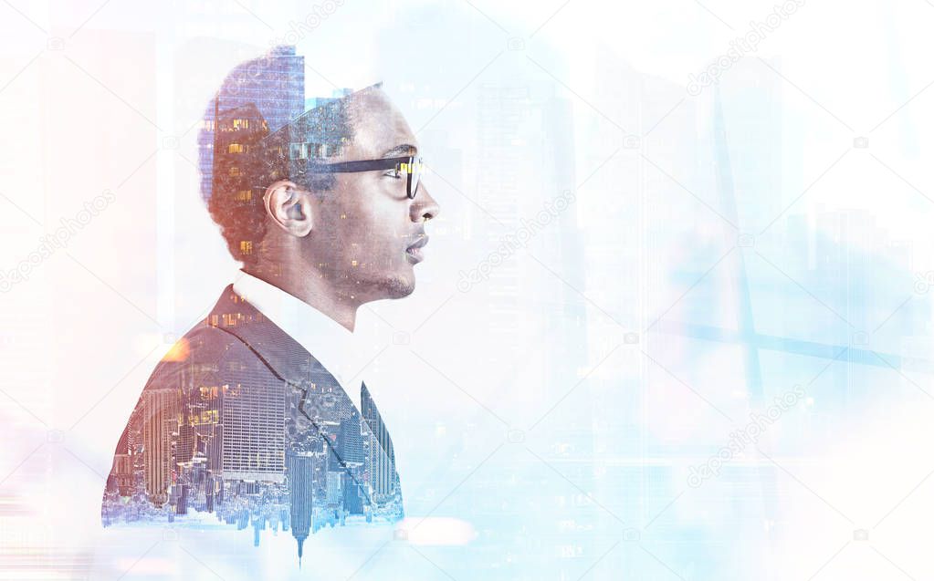 Side view of a young handsome African American businessman wearing glasses and a gray suit. A night city background. Toned image double exposure mock up