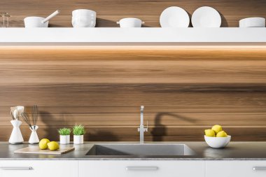 Beyaz mutfak tezgah ile yapılı içinde bir lavabo, tencere ve bir ahşap mutfak iç şişelerde. Uzun bir raf üzerinde asılı plakalı. 3D render alay