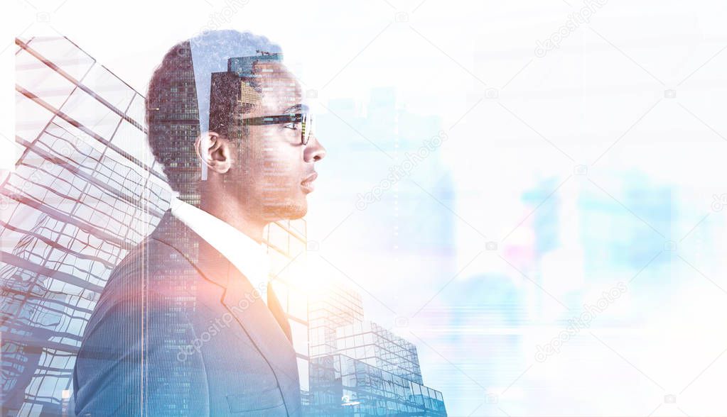 Side view of a young handsome African American businessman wearing glasses and a gray suit. A morning city background. Toned image double exposure mock up
