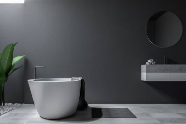 Büyük banyo iç Gri duvarlar, kiremitli bir zemin, yuvarlak ayna ile bir lavabo ve küvet. 3D render alay