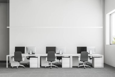 Önden Görünümü gri halı ve beyaz bilgisayar masaları satırlarının bir ofis iç. Sanayi tarzı iç beyaz duvarları ve büyük pencereler ile. 3D render alay
