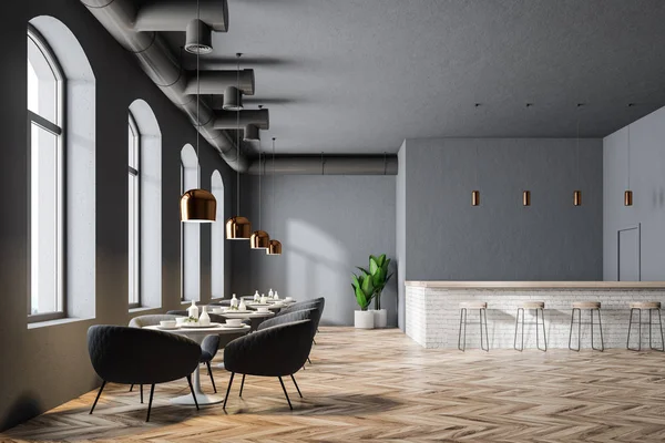 Modern restaurant interior with gray walls, large windows, a wooden floor and round tables with armchairs. A bar with stools. 3d rendering mock up