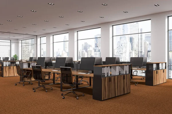 Startup office corner with a brown carpet and rows of wooden computer desks. Industrial style interior with white walls and large windows with a cityscape. 3d rendering mock up