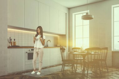 Beyaz duvarları, ahşap zemin ve beyaz mutfak tezgahı ve dolaplar ile şık mutfak iç kadında. Bir masa sandalye manzaralı. 3D render sahte kadar çift tonlu görüntü pozlaması