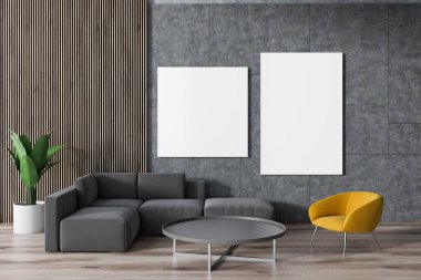 Gri kanepe ve çevresinde gri bir sehpa duvardaki posterler ile beton bir oturma odasında sarı koltuk ayakta. 3D render alay